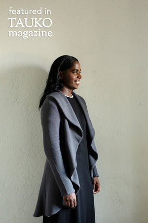 Long Kirsi cardigan in grey, worn open, with black dress, side view
